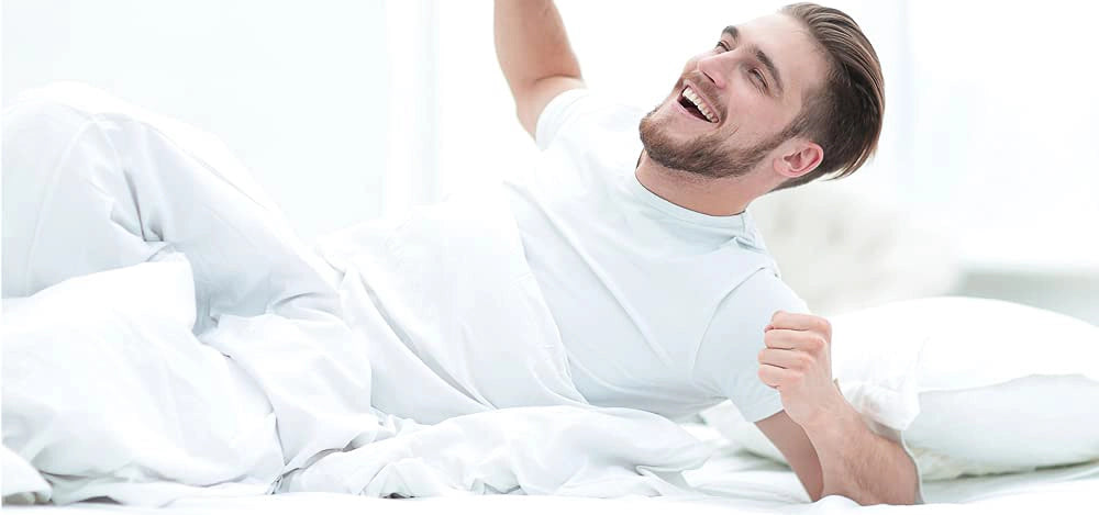 Almofada de perna ortopédica Restform colocada entre os joelhos, ideal para dormir de lado e aliviar a pressão nas ancas e costas.